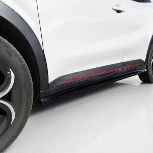 Close-up side view of a white car showing the front wheel, black fender, and red-accented side skirt along the lower body surface