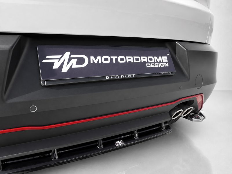 K227-003_4jpg - OPSHOLDERS Rear view of a car bumper with a Motordrome Design license plate and dual exhaust tips on the right side.