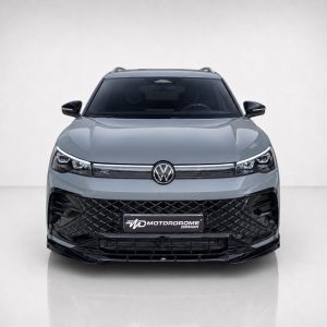 Front view of a gray Volkswagen SUV with a large black diamond-pattern grille and VW emblem on the hood crown.