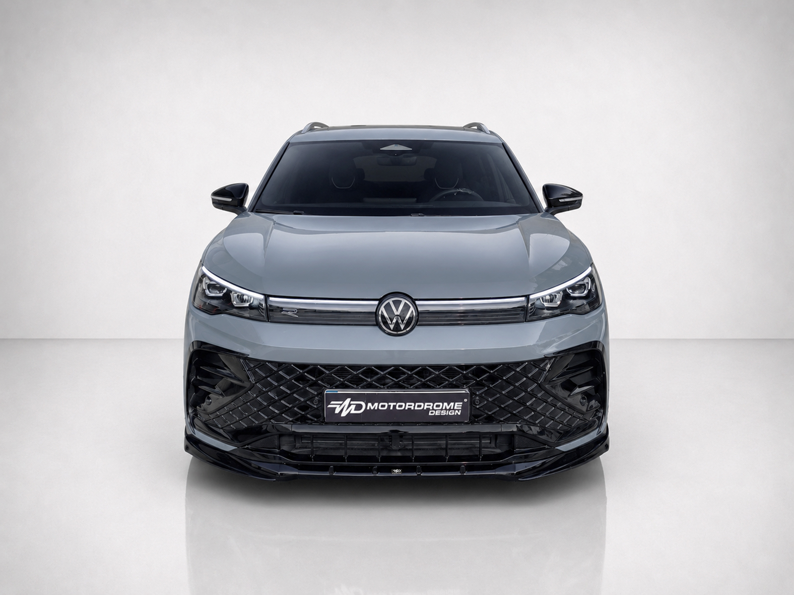 K228-001_1jpg - OPSHOLDERS Front view of a gray Volkswagen SUV with a large black diamond-pattern grille and VW emblem on the hood crown.
