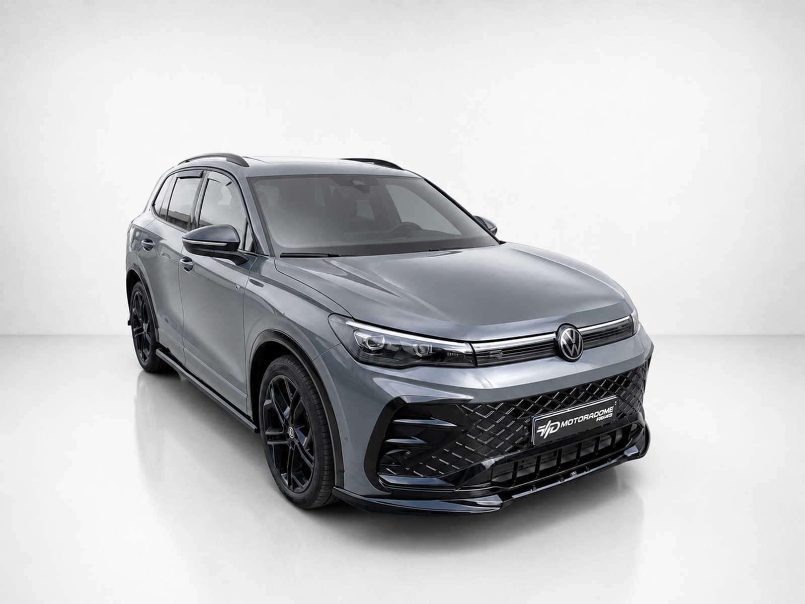 K228-001_2jpg - OPSHOLDERS Grey Volkswagen SUV in a studio setting, front angled view showcasing its bold grille and alloy wheels.