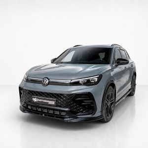 K228-001_3jpg - OPSHOLDERS Front three-quarter view of a blue-gray Volkswagen SUV in a white studio, highlighting the bold black grille and VW emblem.