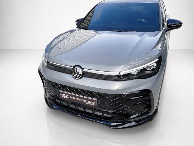 K228-001_4jpg - OPSHOLDERS Front view of a silver Volkswagen with a black mesh grille and sharp LED headlights in a studio setting.
