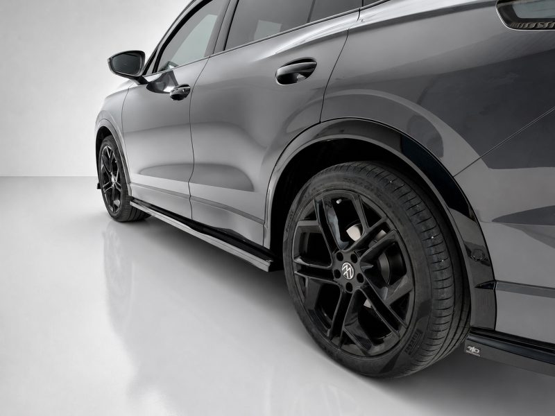 Side view of a gray SUV showing a glossy body, black alloy wheel and lowered side skirt that runs along the bottom.