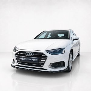 White Audi sedan in a clean studio, showing the front grille and headlights with a Motordrome Design plate.