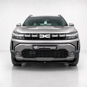 Front view of a silver SUV facing the camera in a studio, showing a bold grille and bumper with a Motordrome Design plate.
