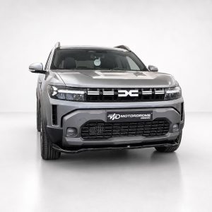 Front view of a silver SUV in a bright studio, with a bold black grille and MD Motordrome Design plate on the bumper.