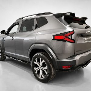 Silver Dacia Duster SUV shown from the rear three-quarter angle in a studio setting, highlighting the taillights, rear bumper, and roof rails