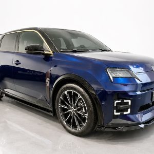 Blue Renault SUV in a studio, shown from a three-quarter front angle with black roof and chrome trim edges.