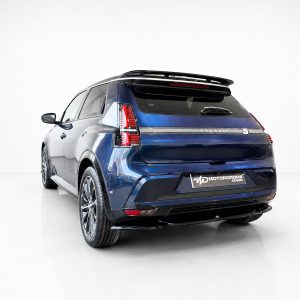 Rear three-quarter view of a blue Renault SUV in a bright studio, with a Motordrome Design plate at the bumper.
