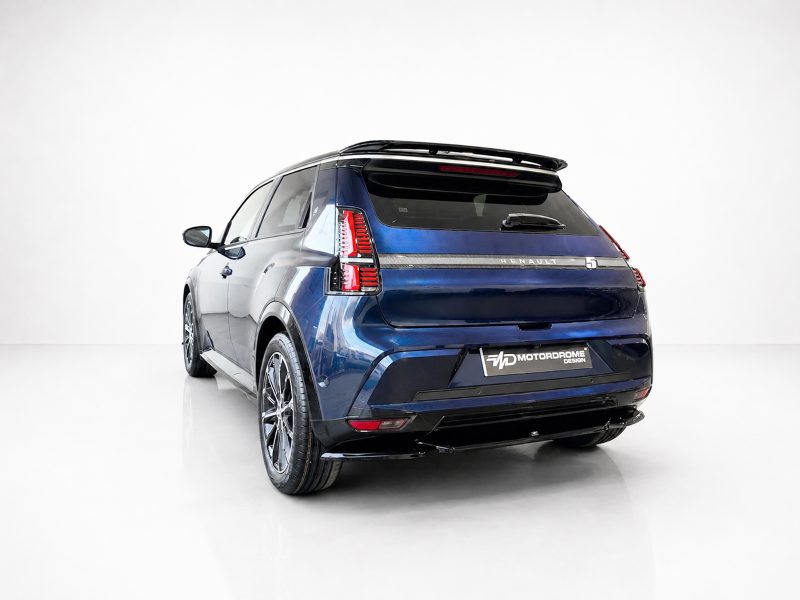 Rear three-quarter view of a blue Renault SUV in a bright studio, with a Motordrome Design plate at the bumper.