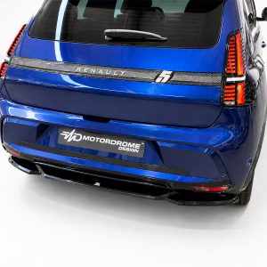 Blue SUV rear view showing vertical red taillights, rear hatch, and a Motordrome Design plate on the bumper strip along a white studio backdrop.