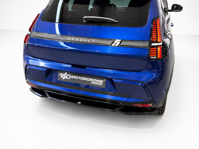 Blue SUV rear view showing vertical red taillights, rear hatch, and a Motordrome Design plate on the bumper strip along a white studio backdrop.