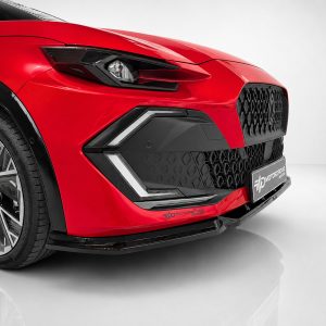 Close-up of a red car's front end, featuring a sharp headlight, honeycomb grille, and sculpted bumper.
