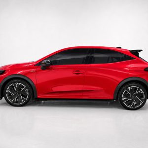 K233-002_2jpg - OPSHOLDERS Side view of a bright red sporty hatchback with black trim and large alloy wheels in a studio setting