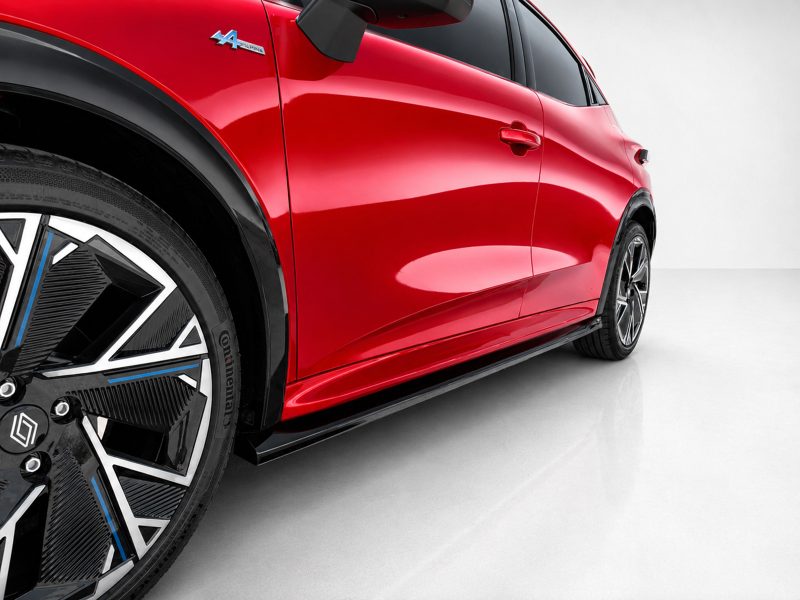 K233-002_6jpg - OPSHOLDERS Red car side panel and large black alloy wheel with blue trim, viewed from a low angle.