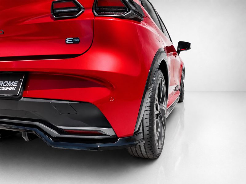 Red sports car rear quarter panel with taillight, bumper, and large alloy wheel in a studio setting.
