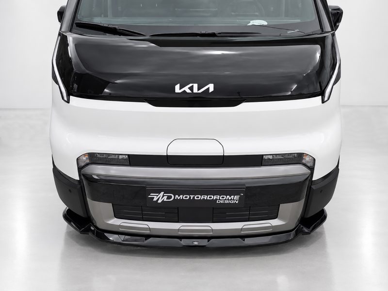 Front view of a white Kia van with black hood, displaying the Kia logo and Motordrome Design license plate area