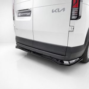 White van rear view with black side skirts and chrome bumper, showing Kia badge and Motordrome Design plate on the back door area in a bright studio setting.