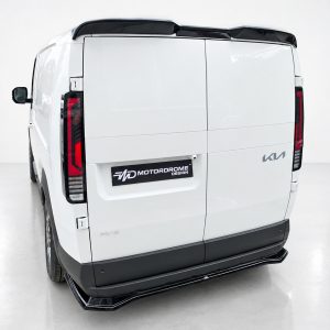 Rear view of a white cargo van with split rear doors, black bumper, and red tail lights; Motordrome Design badge on the lower left door area.