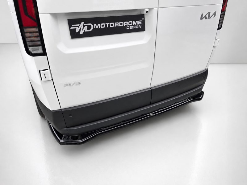 Rear view of a white van featuring a Motordrome Design plate, a Kia badge, and a black running board along the bumper.