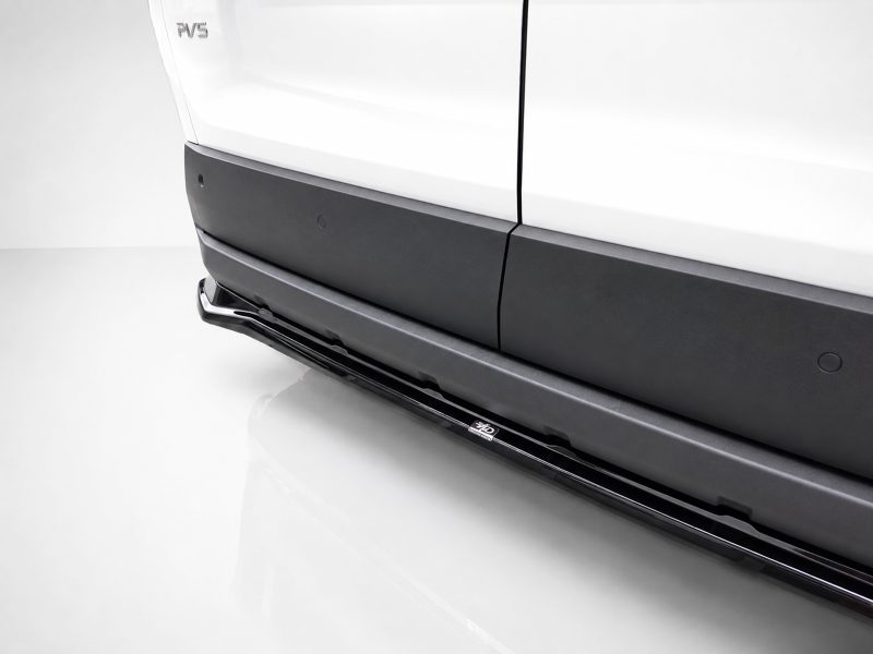Close-up of a white vehicle's lower side, showing black rocker panel and a chrome running board/step.