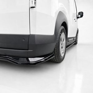 Rear side view of a white van, showing the black lower bumper, wheel, and side trim.