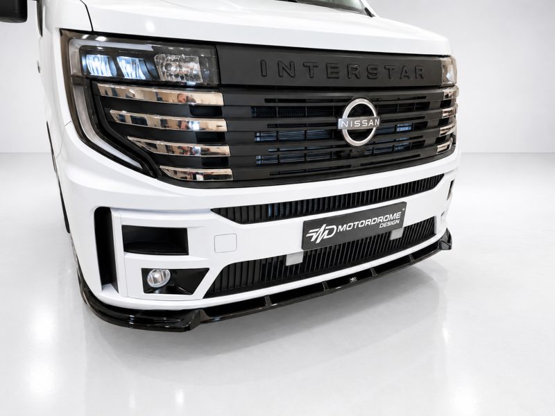 Front view of a white Nissan Interstar truck with a black grille and chrome accents, headlights visible at left