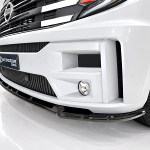 White car front close-up showing an aggressive bumper design, black grille, fog light, and a MotorDome Design plate