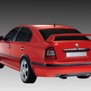 Rear-left view of a red four-door sedan with a large rear spoiler, alloy wheels, and dual exhausts.
