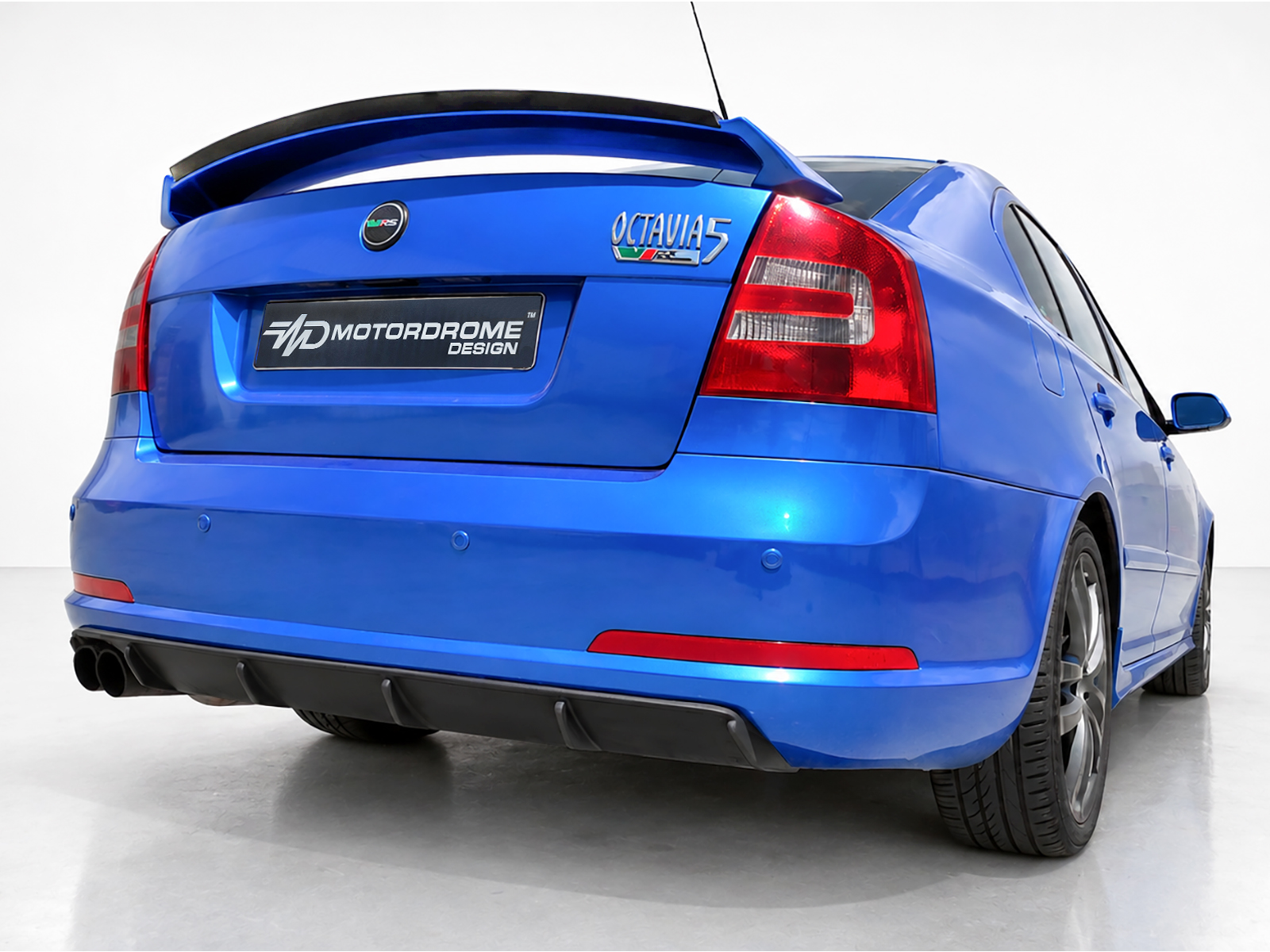 K43-008_2jpg - OPSHOLDERS Blue Skoda Octavia vRS rear view with a large rear spoiler and black Motordrome Design plate on a clean studio backdrop.
