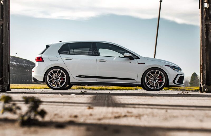 Mk8-GTI-Racingline-Lowering-Springs-scaled-2jpg - OPSHOLDERS White luxury SUV photographed in a side view, framed by dark metal pillars outdoors on a sunny day