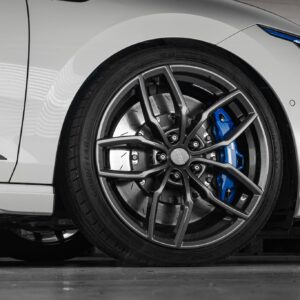 Mk8-R-Lowering-Springs-1jpg - OPSHOLDERS Close-up of a white car's front wheel showing a silver alloy rim and blue brake caliper behind it.