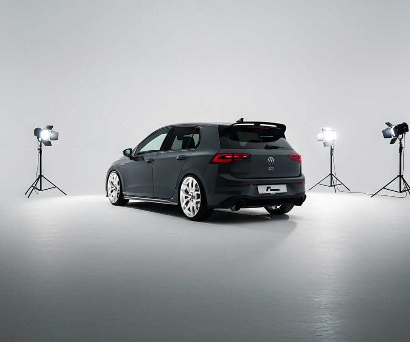 Gray Volkswagen GTI wagon photographed in a white photography studio with four bright lights surrounding the car.