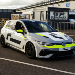 Racingline-Cup-Edition-EVO-Wheels-VWR610010_5-1jpg - OPSHOLDERS White race car with neon yellow accents parked on a race track, branding and photographers’ tent in background