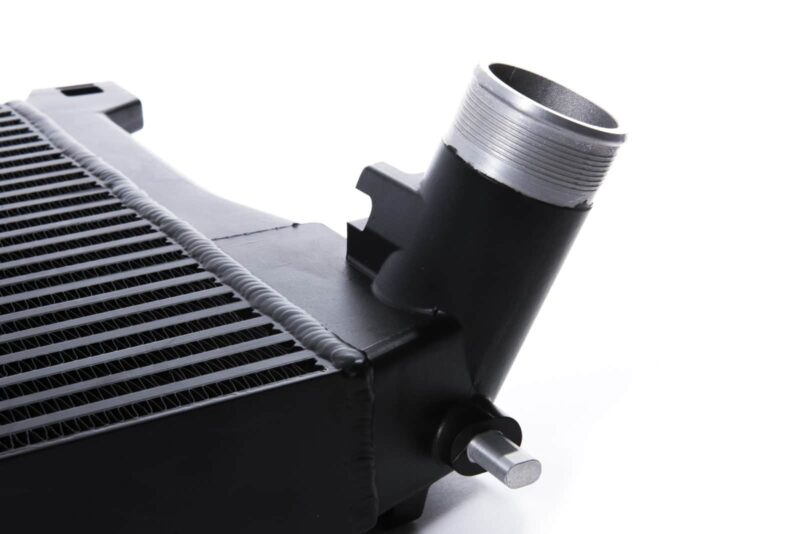 Racingline-MQB-Intercooler-4-1jpg - OPSHOLDERS Close-up of a black radiator with a silver threaded inlet pipe on the side