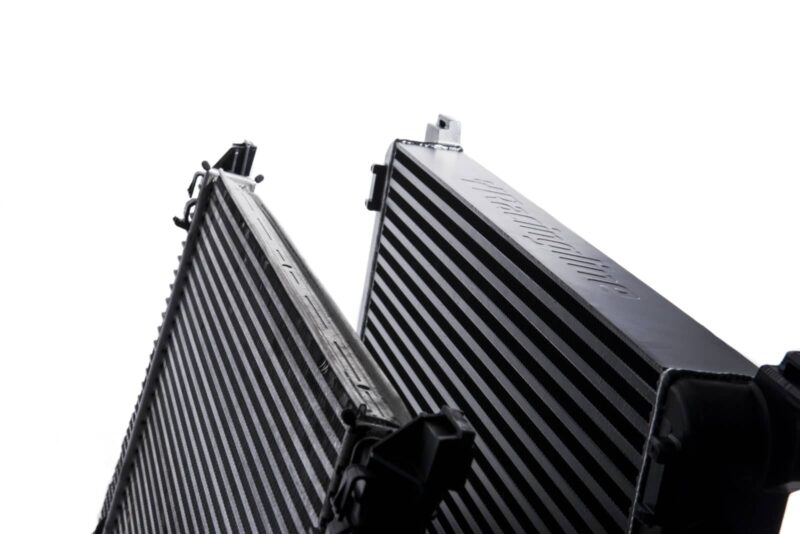 Racingline-MQB-Intercooler-8-1jpg - OPSHOLDERS Two large finned metal heat sinks arranged in a V, for cooling components.