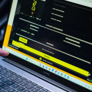 Racingline-PDM-Home-Tuning-VWR031000_4-1jpg - OPSHOLDERS Close-up of a laptop screen showing a dark software interface with yellow highlights and a finger pointing at a Download button.