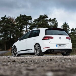 Racingline_Lowering_Springs_MK7Rjpg - OPSHOLDERS Rear three-quarter view of a white Volkswagen Golf R parked on a rocky dirt road with a forest backdrop.