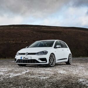 Racingline_Lowering_Springs_MK7R_1jpg - OPSHOLDERS White Volkswagen Golf R parked on a gravel lot with a barren hillside and cloudy sky in the background