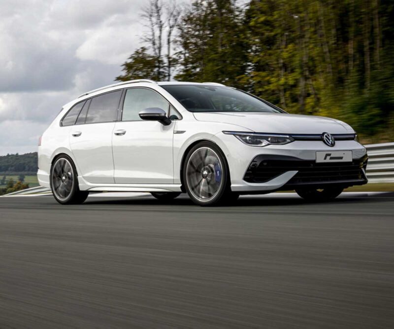 Racingline_Springs_MK8R-Estate_1jpg - OPSHOLDERS White Volkswagen station wagon driving at speed on a racetrack with blurred pavement and trees in the background