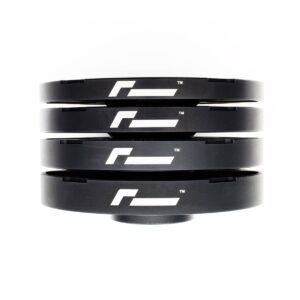 Spacers5-1jpg - OPSHOLDERS Four black circular rings stacked on a white background, each with a white stylized logo on the side.