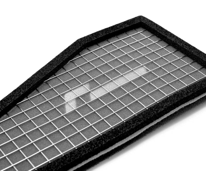Close-up of a rectangular air filter with a metal grid and black foam frame.