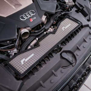 Close-up of an Audi RS engine bay with exposed components and a front grille mesh panel