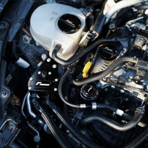 Close-up of a car engine bay with aftermarket black aluminum component and braided hoses.