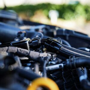 Close-up of a car engine bay focusing on hoses, clamps, and connectors.