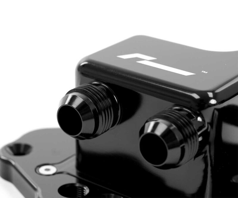 Close-up of a glossy black optical device with two protruding tubes, likely part of a microscope or camera accessory.