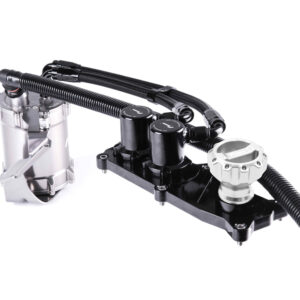 Close-up of a metallic automotive hydraulic unit with black connectors and braided hoses mounted on a black base panel, likely part of a fluid control system.