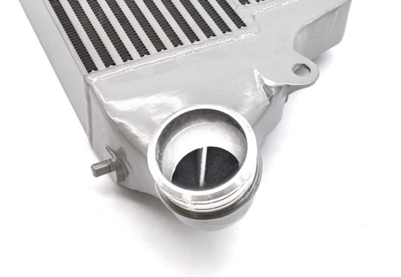 VWR143000_6-1jpg - OPSHOLDERS Close-up of a silver automotive intercooler with a circular inlet/outlet port and mounting flange, used to cool turbocharged air