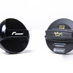 Two black round caps on a white surface, left cap plain and glossy, right cap branded with Castrol and the word 'recommended'.